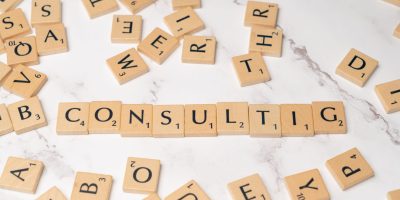 Scrabble tiles spelling 'Consulting' on a stylish marble surface symbolize strategic creativity.