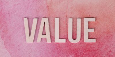 The word 'VALUE' in bold letters on a textured pink background.