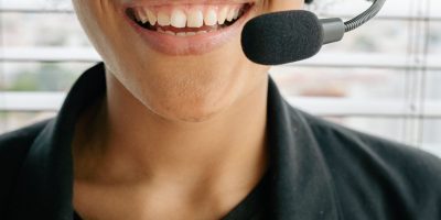 Smiling woman in a headset offering excellent customer service from indoors.